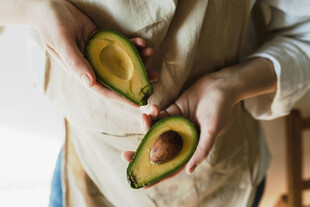 双手捧持切开的牛油果