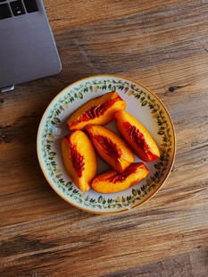 木桌上盘中美味桃子切片