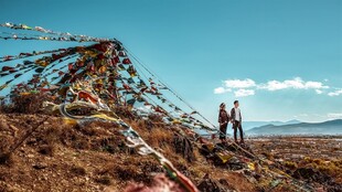 高原经幡旁的两人身影