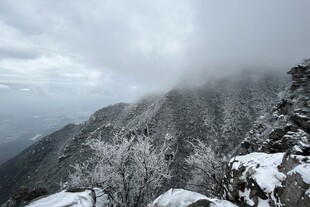 雪覆山峦云雾绕