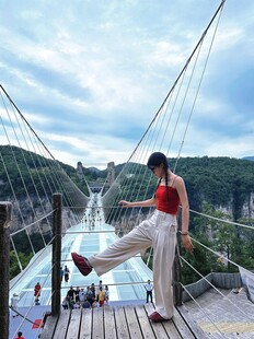 女子于吊桥惬意伸展身姿