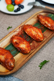 美味烤鸡翅摆于木盘上