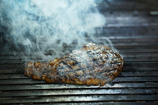 烤架上滋滋冒气的烤肉
