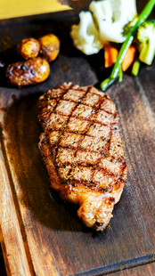 美味烤牛排摆放在木砧板上