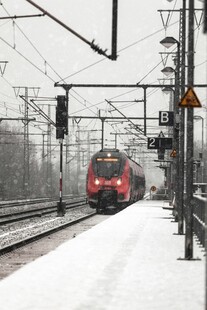 雪中铁轨上行驶的红色列车