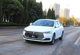 白色轿车行驶在城市道路