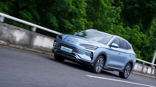 蓝色轿车行驶在道路边