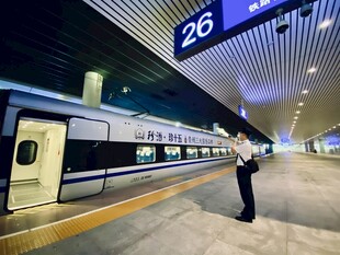 车站工作人员指挥高铁列车