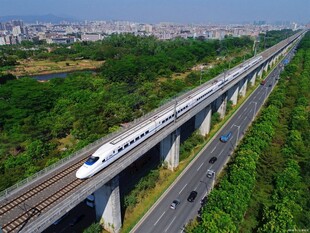 高铁穿行于公路与绿野间