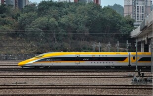 黄色高铁停靠在铁轨旁