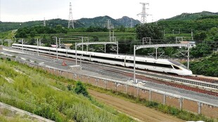 高速列车穿行于青山绿野间