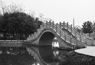 中式拱桥映于平静水面