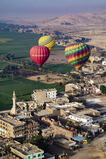 空中俯瞰多彩热气球下的城镇