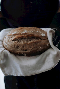 手捧新鲜出炉的全麦面包