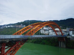 红色拱形大桥横跨绿野