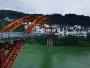橙红色拱桥横跨碧绿河水