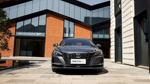 黑色轿车停于现代建筑前