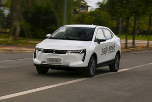 白色轿车行驶在城市道路上