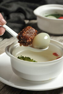 勺子盛着肉丸与汤圆