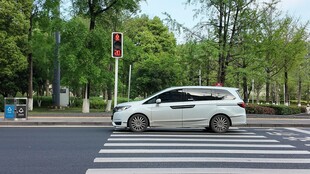 白色轿车行驶在城市道路