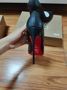 手捧黑色红底高跟鞋