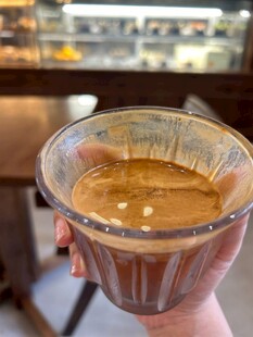 手持透明杯中的香浓咖啡