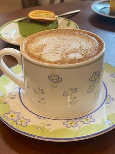 精致花纹杯中的拉花咖啡