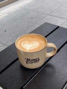 木桌上的拉花咖啡杯