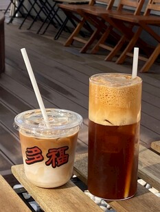 两杯特色饮品置于木桌