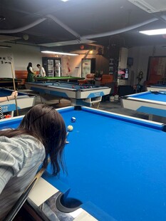 女子专注打台球场景