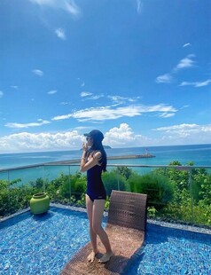 女子于泳池畔眺望美丽海景