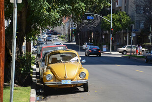 复古小黄车行驶在城市街道