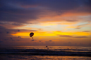 海边日落时的浪漫滑翔伞