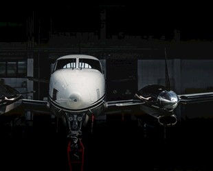 夜间停机坪上的双引擎飞机