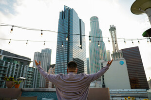 男子于都市背景下舒展双臂