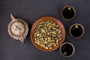 黑背景上的干菊花与茶具