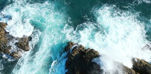 俯瞰澎湃海浪拍打礁石