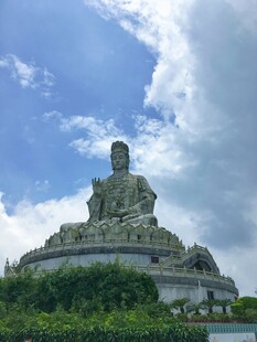 巍峨佛像观音菩萨屹立蓝天白云下