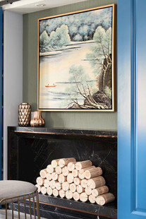 蓝色墙边壁炉上的艺术挂画