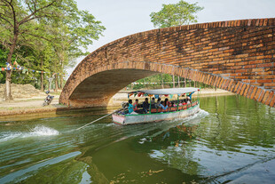 河上拱桥下的游船风景