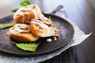 美味肉桂卷置于黑色盘上