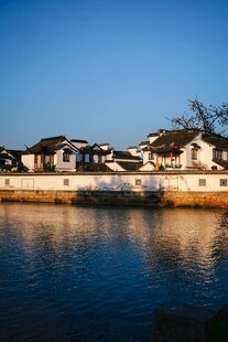 湖畔白墙黑瓦民居美景