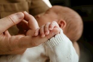父母轻握婴儿小手温馨瞬间
