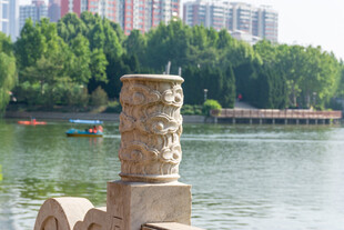 湖边雕刻石柱城市风光