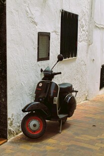 复古摩托车停靠在白墙旁