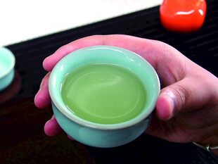 手持青绿茶杯赏茶汤