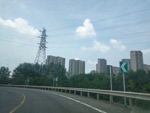 公路旁的城市与输电塔景观