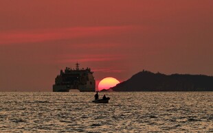 海上夕阳下的船只与小船