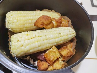 锅中煮着玉米与油条