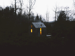 黄昏中亮灯的林间小屋